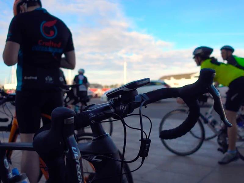 Photo of bicycle handlebars with cyclists in background